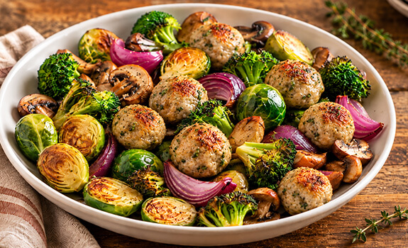 Turkey meatballs in ceramic dish with roasted vegetables